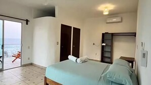 A bedroom with a bed, a ceiling fan, an air conditioning unit, and a view through a glass door. - Grecas del mar house. (Zipolite)