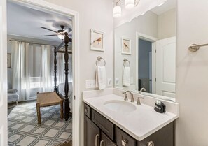 A bathroom with a double sink, a large mirror, and a ceiling fan. - Anchor & Oar Cottage (Tullahoma)