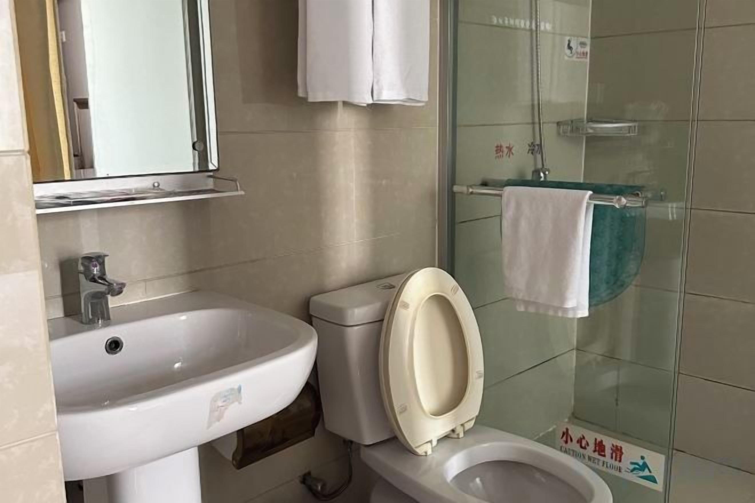 Un baño con lavabo, inodoro y cabina de ducha de vidrio.