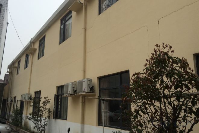 A building with multiple windows and air conditioning units.
