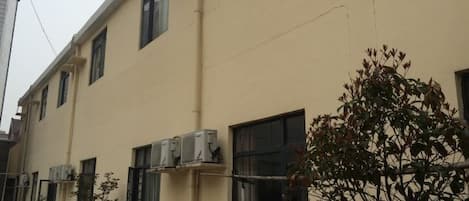 A building with multiple windows and air conditioning units.