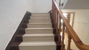 A staircase with a wooden handrail and white steps. - Lexin Business Hotel (Wuxi)