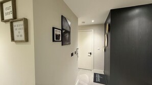 A hallway with framed inspirational quotes, a door, and a welcome mat. - Luxury Manchester City Centre Apartment (Manchester)