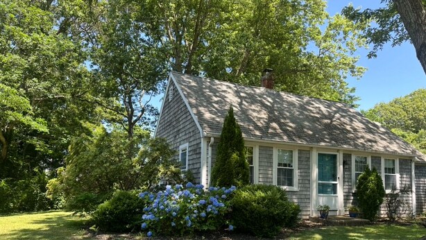 A single-story house with a gabled roof, surrounded by a well-maintained lawn and a variety of trees and shrubs. - End of season price drop! Sandwich recent renovate, single house, close to beach (Sandwich)