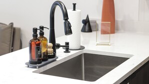 A modern kitchen with a black faucet, a soap dispenser, and a paper towel holder. - Unit 4: Studio / Queen+Sofa Bed|DC Convention Centre (Washington)