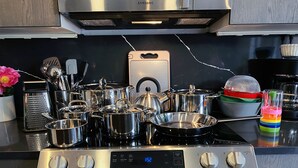 Une cuisine équipée d’une cuisinière, d’un four et de différents ustensiles de cuisine, le tout en acier inoxydable.