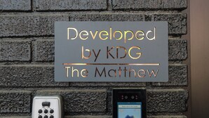 A sign with the text "Developed by KDG The Matthew" mounted on a brick wall. - Unit 7: Spacious 3BR+Sofa bed | Sleeps 10 (Washington)