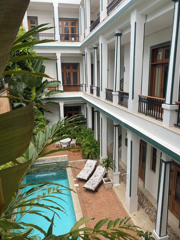 A multi-level hotel with a swimming pool, outdoor seating, and lush greenery. - Boutique Hotel Casa Grande, Chocolate Paradise Studio (Santo Domingo)