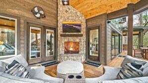 Un interior acogedor con chimenea de piedra, asientos cómodos y ventanas amplias.