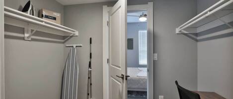A compact room with a bed, a desk, and storage shelves.