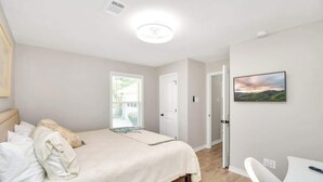 Une chambre à coucher avec un lit, une table de chevet et un tableau accroché au mur.
