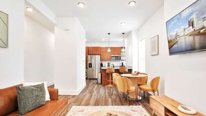 A modern apartment with a living room, dining area, and kitchen.
