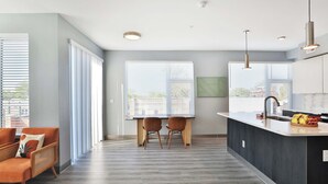 Una cucina moderna con un'isola centrale, due sedie e un tavolo da pranzo.
