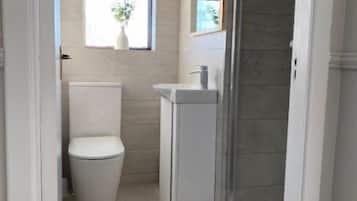 A small bathroom with a toilet, sink, and a window.