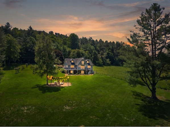 A large house with a well-maintained lawn and a patio area. - Riverbank Retreat - Hot Tub, Game Room, & Fantastic River Access (Jefferson)