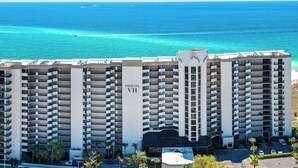 A high-rise hotel with multiple balconies, a prominent 'Phoenix VII' sign, and a view of the ocean.