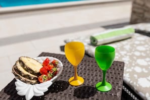 A table with a bowl of oysters and strawberries, two wine glasses, and a rolled-up towel. - Holiday home mit Pool und Terrasse (Vela Luka)