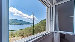 Una habitación con vista a un lago y montañas.