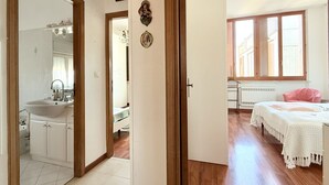 Un dormitorio con cama, ventana y puerta que da a un baño.