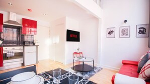 Un espacio habitable moderno con cocina, comedor y un sofá rojo.