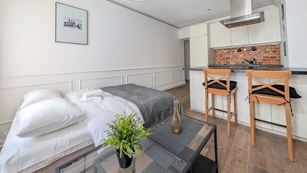 Un appartement moderne et compact comprenant un coin cuisine, un espace repas et une chambre.
