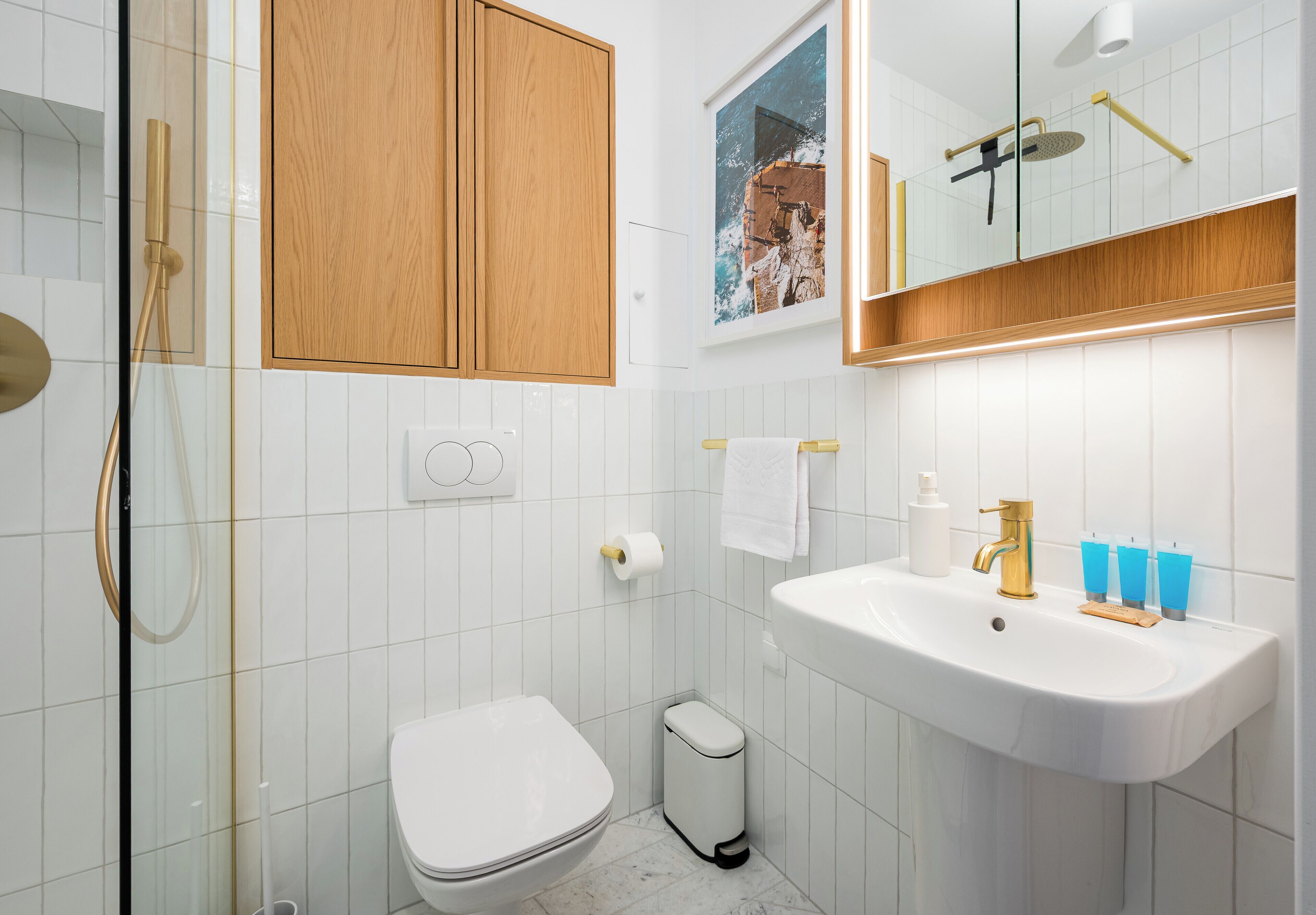Moderni kylpyhuone, jossa on wc, pesuallas ja suihku.