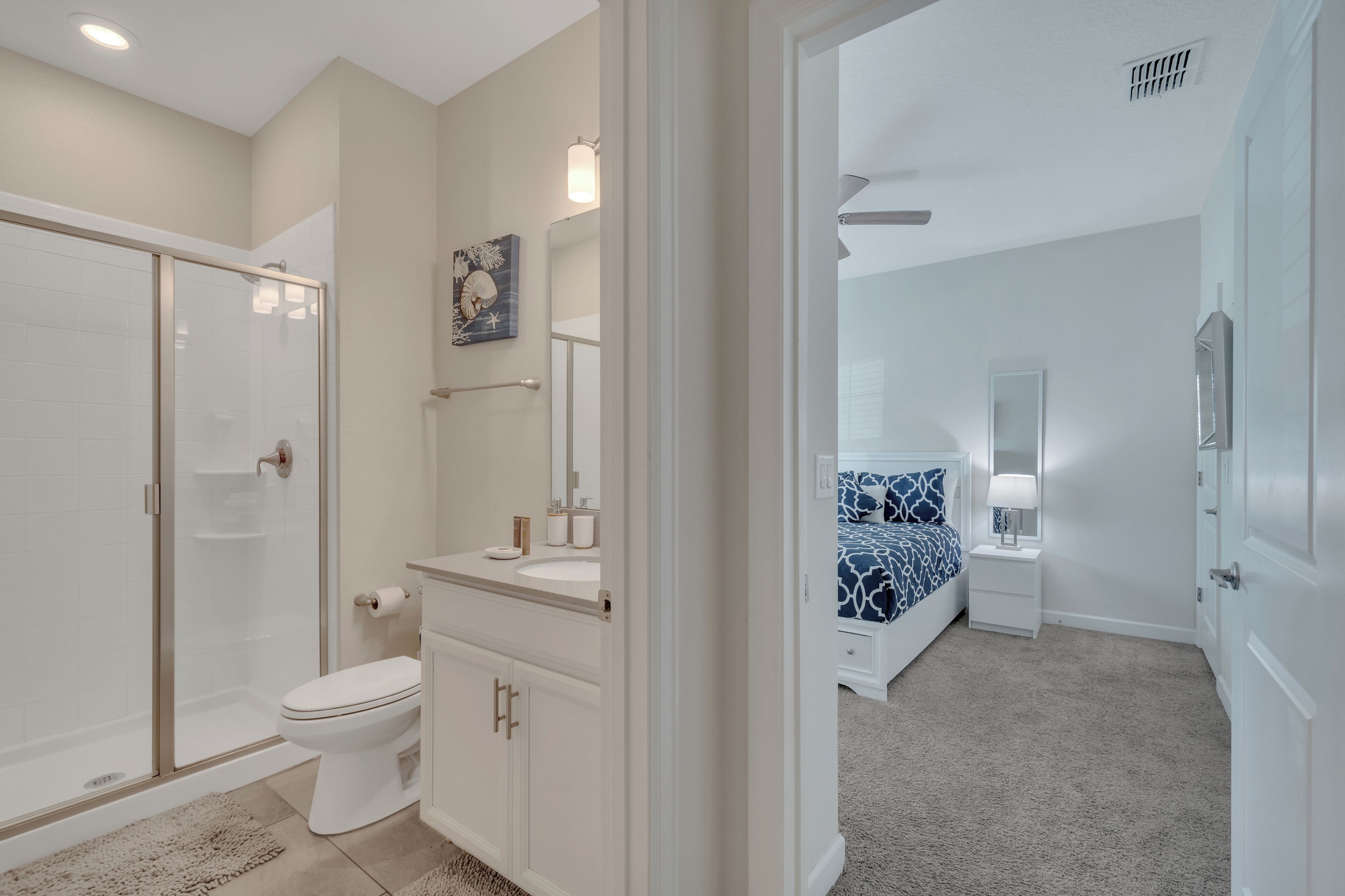 A modern bathroom with a glass shower enclosure, a toilet, and a vanity with a mirror.
