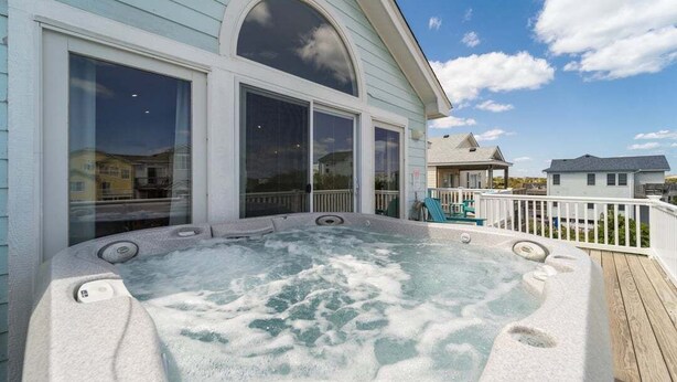 A hot tub on a wooden deck with a view of a house and a clear sky. - Dune Fabulous | 1,200 ft to the beach | Private Pool, Hot Tub, and Dog Friendly (Corolla)