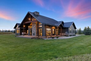 A modern house with a stone facade, large windows, and a metal roof. - Teton Homestead: Grande Dom Private Estate (Tetonia)