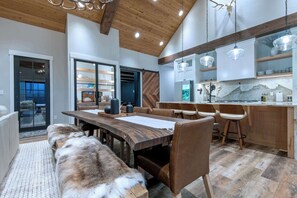 A modern kitchen with wooden cabinets, a marble countertop, and pendant lighting. - Teton Homestead: Grande Dom Private Estate (Tetonia)