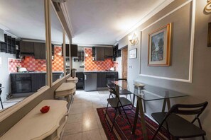 Réfrigérateur, un four, surface de cuisson, vaisselle et ustensiles