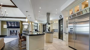 A modern kitchen with a central island, stainless steel appliances, and a dining area with a fireplace.