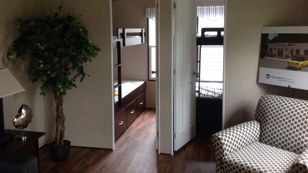 A compact room with a bed, a desk, a chair, a potted plant, and a window. - Charming and Cozy 3-bedroom cottage w/AC, WiFi in enchanting Niagara-on-the-Lake (Niagara-on-the-Lake)