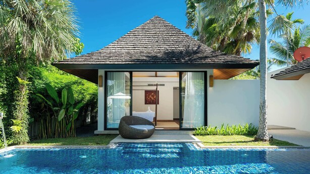 A modern poolside villa with a tiled roof, a glass-enclosed bedroom, and a pool.