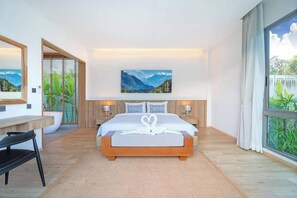 Une chambre moderne avec un grand lit, un bureau et une vue sur la verdure.