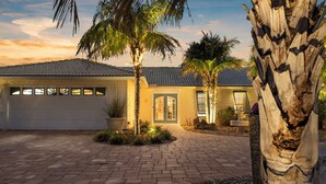 A residential house with a garage, a paved driveway, and palm trees. - ⚓Dolphin Cabin! Screened Pool, Dock & More! ⚓ (Bradenton)