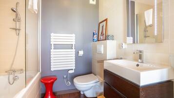 A modern bathroom with a bathtub, toilet, and sink.