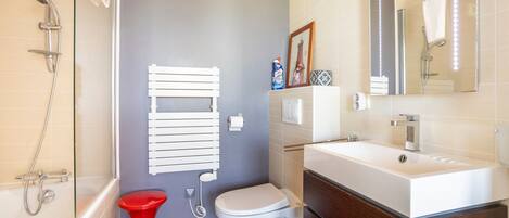 A modern bathroom with a bathtub, toilet, and sink.