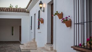 A building with white walls, a tiled roof, and steps leading to a door. - Villa 'El Arroyo Ronda' with Mountain View, Wi-Fi and Air Conditioning (Ronda)
