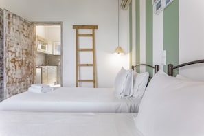 A bedroom with a bed, a wooden ladder, a hanging light, and a view of a bathroom and kitchen. - Apartment 'Bel Momento - Family Room' with Sea View, Wi-Fi and Air Conditioning (Alikanas)