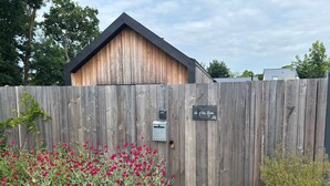 A wooden fence with a mailbox and a sign indicating a house number. - Holiday Home “La P’tite Maison” with Private Terrace, Garden & Wi-Fi (Le Minihic-sur-Rance)