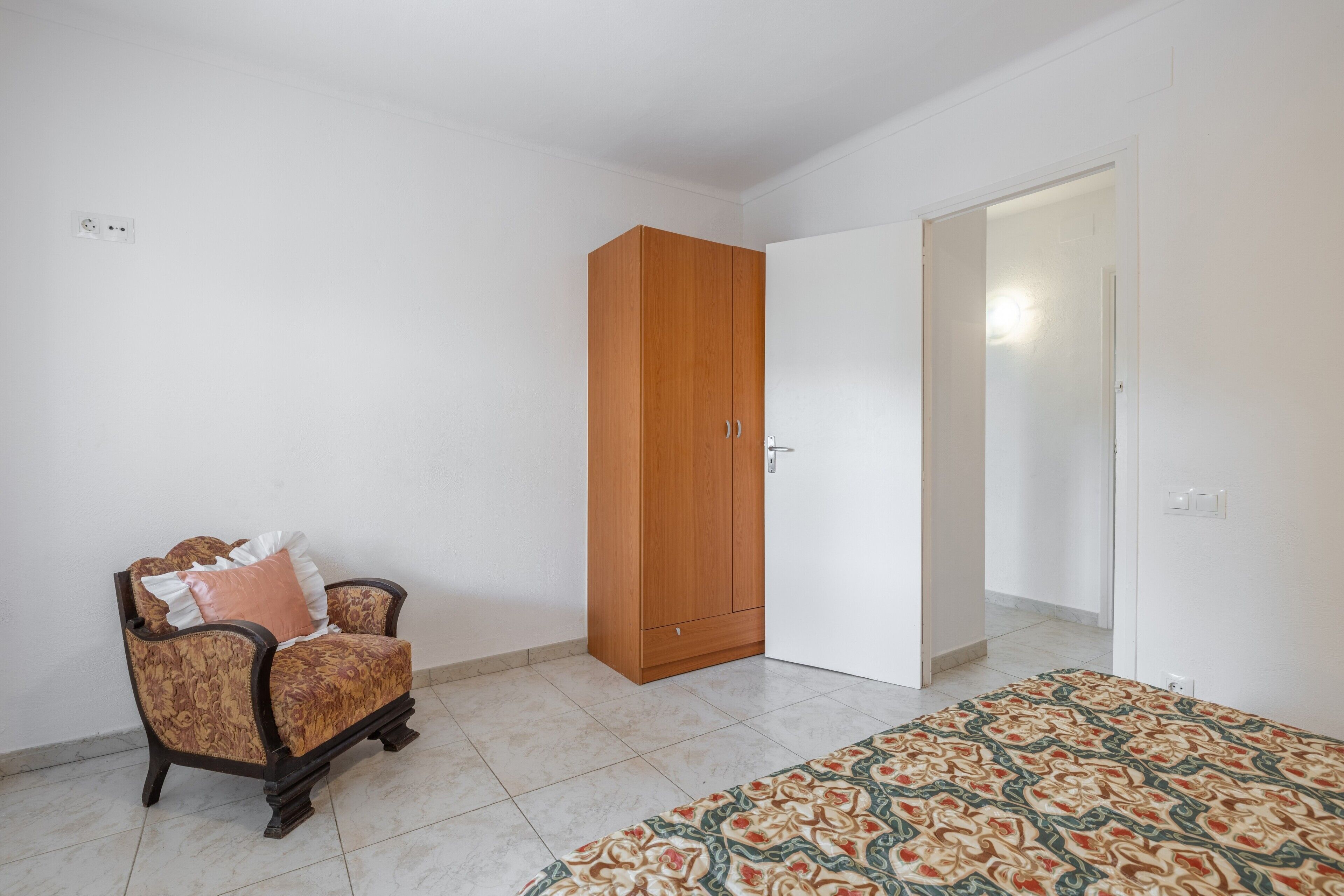 Una habitación con un sofá estampado, un armario y un tapete con diseño.