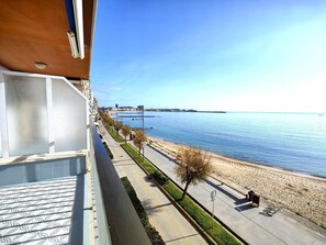A balcony with a view of a beach and the sea.