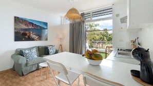 A modern kitchen with a dining area, a large window with a view, and a painting on the wall. - Vacation 'Beautiful Sea View and Pool Finca 1' with Shared Pool, Private Terrace and Wi-Fi (Adeje)