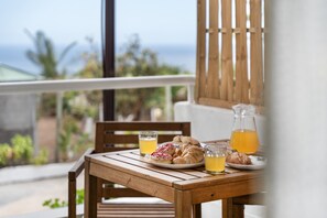 A wooden table with breakfast items and drinks on a balcony overlooking the ocean. - Vacation 'Beautiful Sea View and Pool Finca 2' with Shared Pool, Private Terrace and Wi-Fi (Adeje)