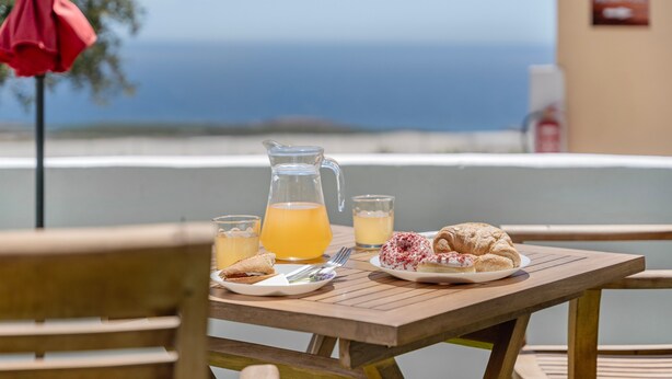 A table with a pitcher, glasses, and plates of food, overlooking a scenic view. - Vacation 'Beautiful Sea View and Pool Finca 3' with Shared Pool, Private Terrace and Wi-Fi (Adeje)