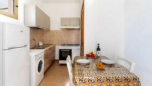 A compact kitchen with a washing machine, stove, and sink. - Cenate House Holiday Home (Nardò)