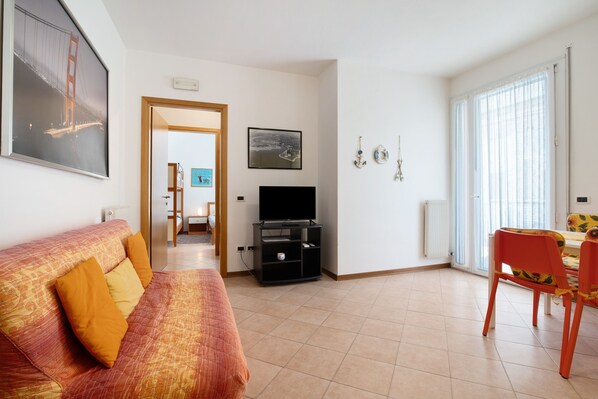 Ein Wohnzimmer mit Sofa, Fernsehschrank und Essbereich.