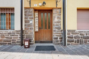 A stone building with a wooden door, numbered 7, and a mailbox.
