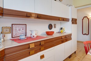 A kitchen with wooden cabinets, a white countertop, and various kitchen items.